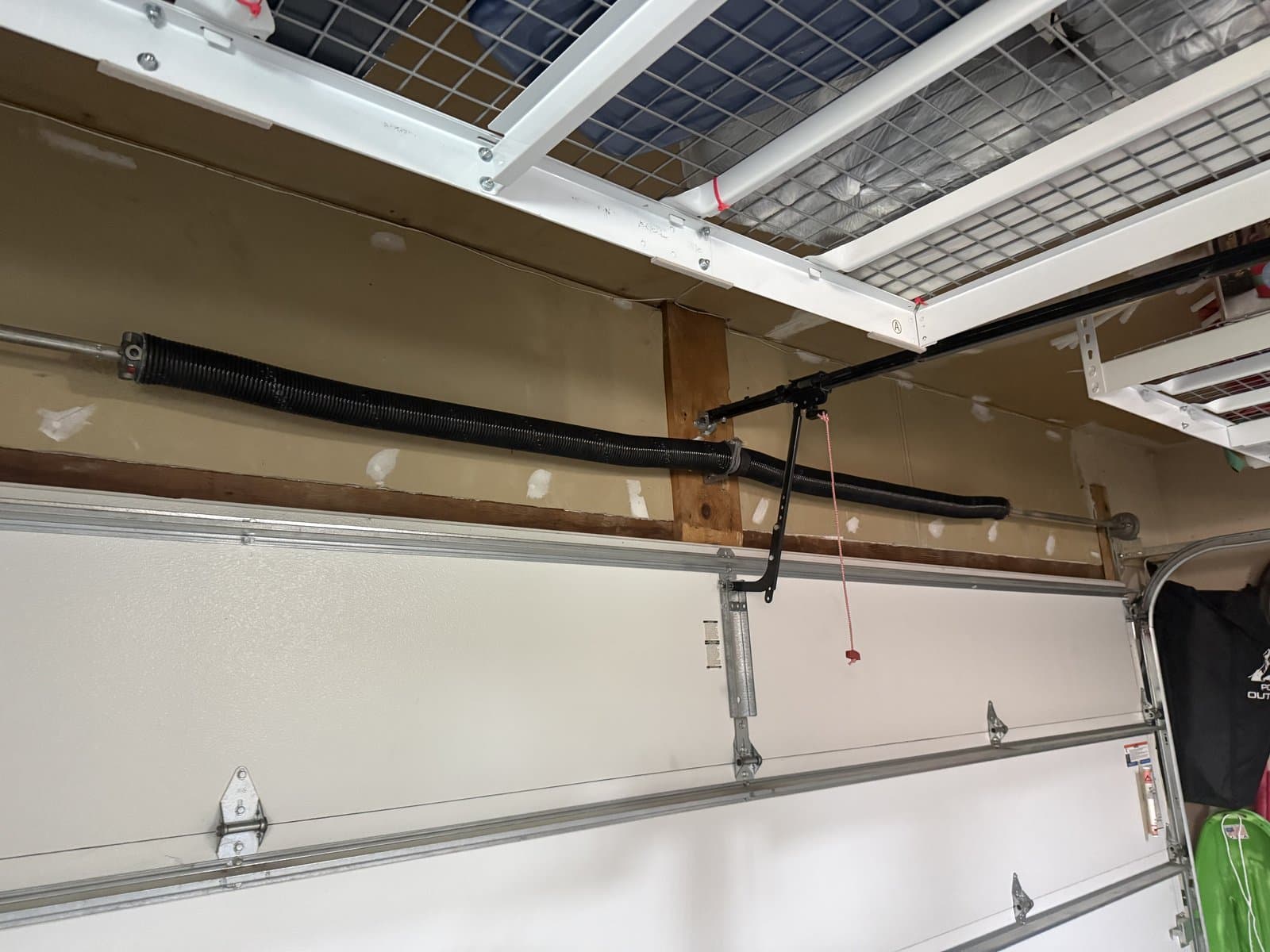 High-cycle garage door torsion springs installed on the spring line above a residential garage door